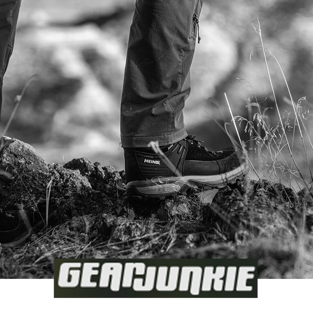 Meindl Air Revolution Alpine 1.5 Light Hiker – As Featured in Gear Junkie – Gore-Tex Waterproof Hiking Boot Worn by Hiker Stepping on Volcanic Rock and Dry Grass Terrain