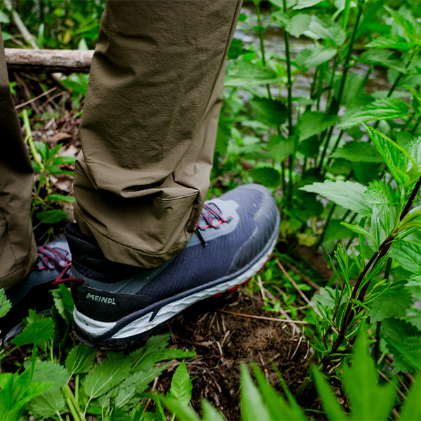 Meindl Comfort Fit Power Walker 4 Mid – Navy Blue and Red Low-Cut Gore-Tex Trail Shoe Worn While Walking Through Dense Green Forest Undergrowth