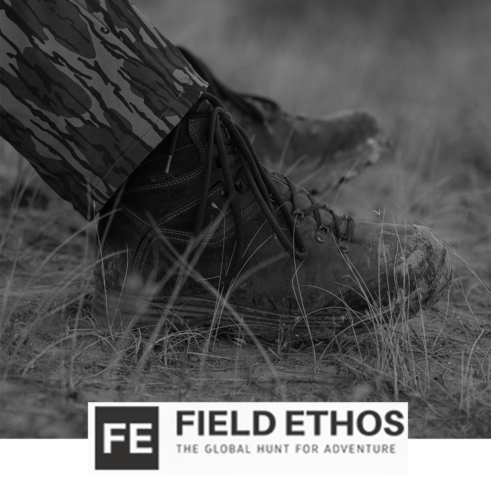 Meindl Comfort Fit Hiker – As Featured in Field Ethos Magazine – Full-Grain Leather Hiking Boot Worn by Hunter in Camouflage Stepping Through Dry Grass and Dirt Terrain