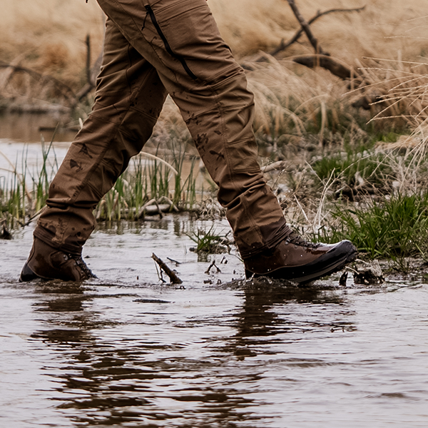 Meindl Comfort Fit Pro Hunter Uninsulated– Brown Leather Gore-Tex Hunting Boot Worn While Wading Through Shallow Water in Wetland Terrain With Tall Grass and Brush in Background