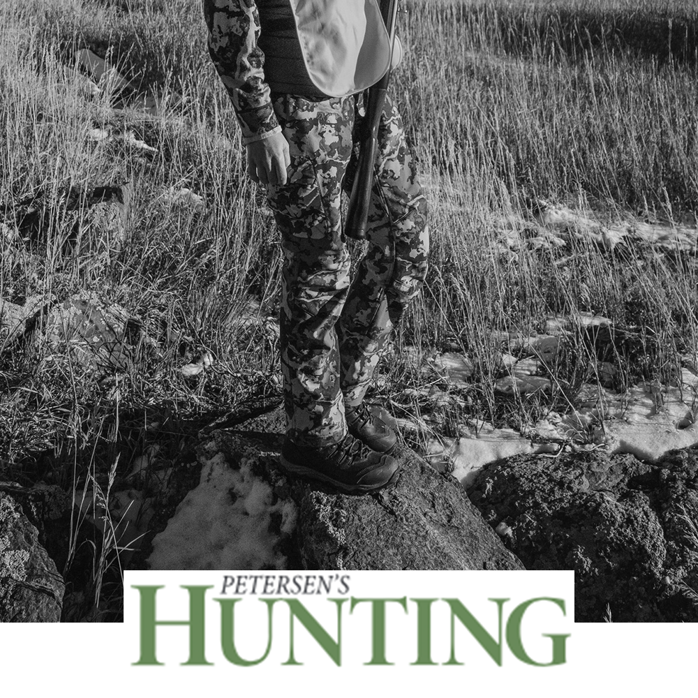 Meindl Lady EuroLight Hunter 300 – As Featured in Petersen's Hunting Magazine – Women's 300g Insulated Lightweight Hunting Boot Worn by Female Hunter in Camouflage Holding Shotgun in Rocky Grass Field