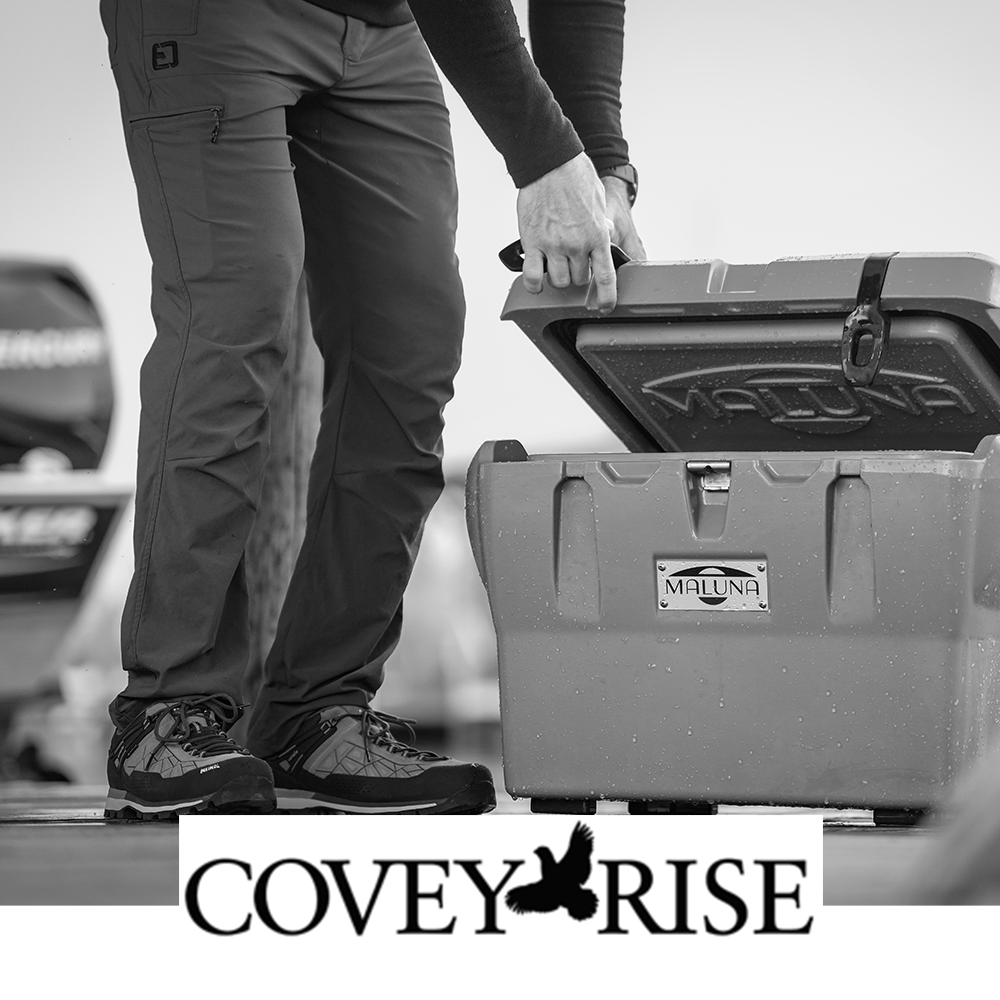 Meindl Literock Free Trail Shoe – As Featured in Covey Rise Magazine – Gore-Tex Lightweight Trail Shoe Worn by Outdoorsman Standing Beside Boat on Dock While Lifting Waterproof Storage Cooler