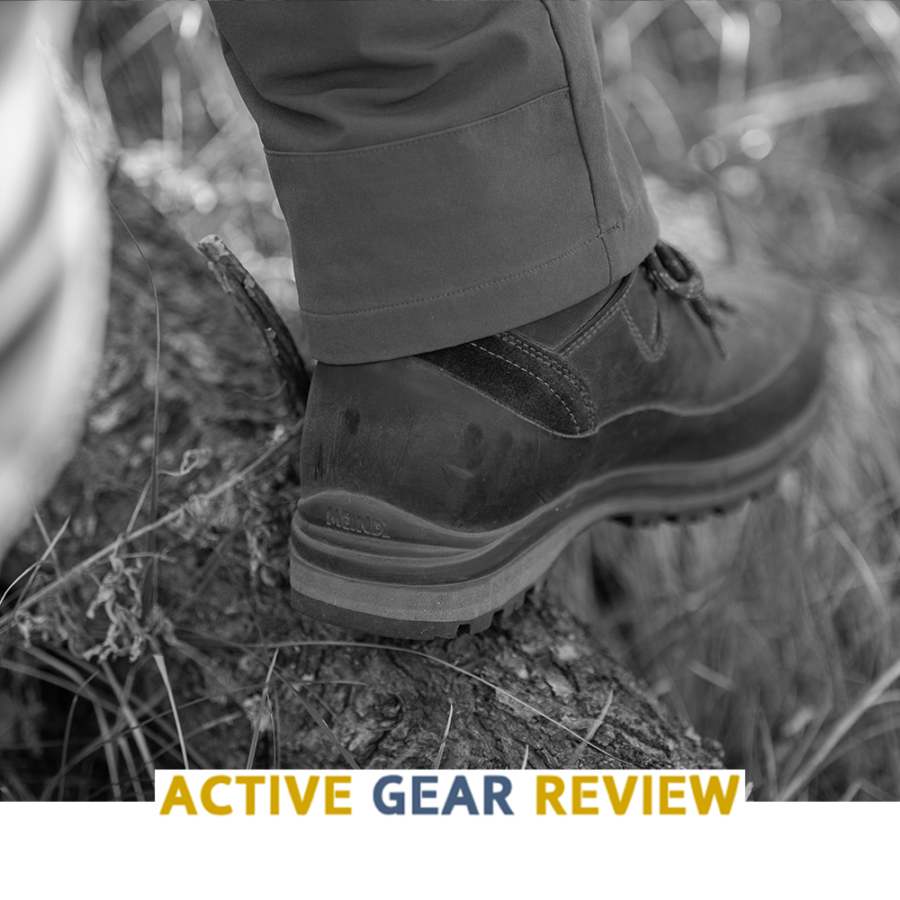 Meindl MFS Vakuum Hiker – As Featured in Active Gear Review – MFS Vakuum Custom-Fit Leather Hiking Boot Worn by Hiker Stepping on Rocky Log in Forest Terrain Showing Heel and Outsole Detail