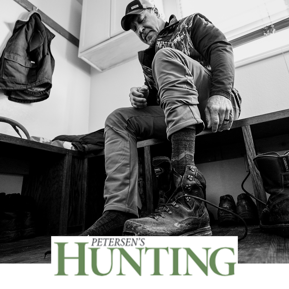 Meindl MT3.5 Merino Wool Sock – As Featured in Petersen's Hunting Magazine – Mid-Weight Merino Wool Hunting Sock Worn by Hunter Lacing Up Well-Worn Hunting Boot in Gear Room Setting