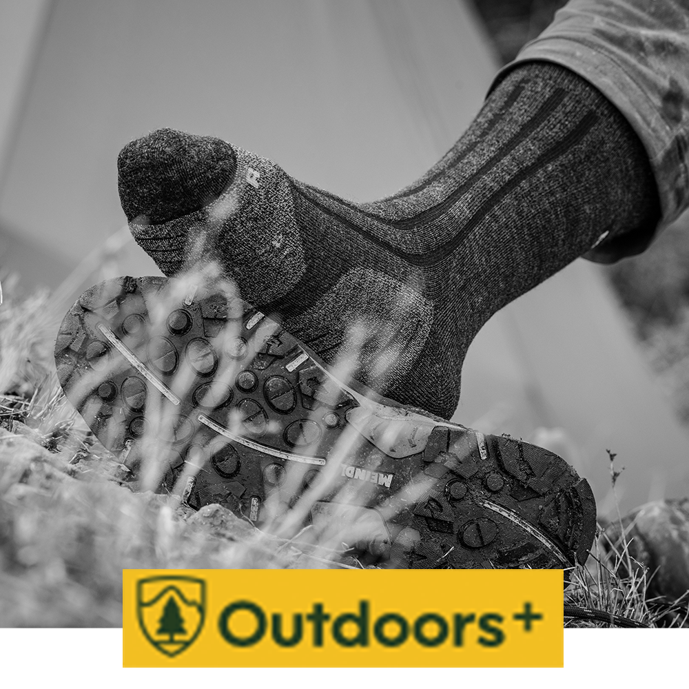 Meindl MT8 Heavyweight Merino Wool Sock – As Featured in Outdoors+ – Heavyweight Merino Wool Sock Worn by Hiker Stepping Onto Meindl Boot Lugged Outsole on Rocky Terrain Showing Sole Tread Detail