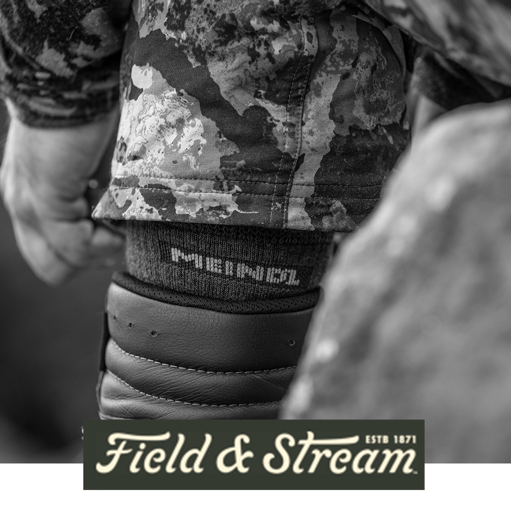 Meindl MTJagd Long Merino Wool Hunting Sock – As Featured in Field and Stream Magazine – Extended-Height Merino Wool Hunting Sock Worn by Hunter in Camouflage Pants With Leather Boot on Rocky Terrain