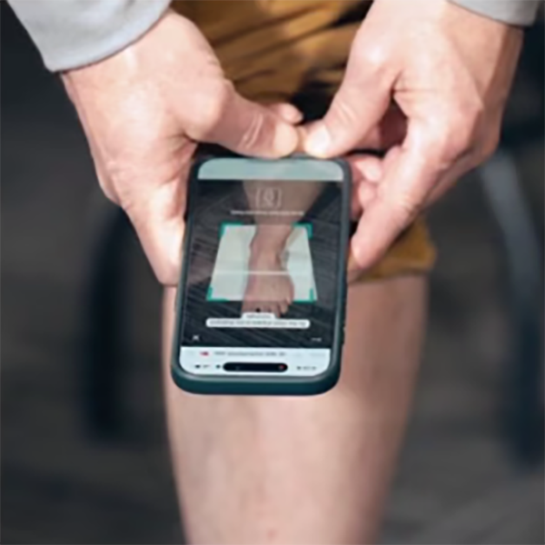 Meindl Perfect Fit Tool – Close-Up of Hands Holding a Smartphone Scanning a Bare Foot to Measure Size and Width for Precise Boot Fitting