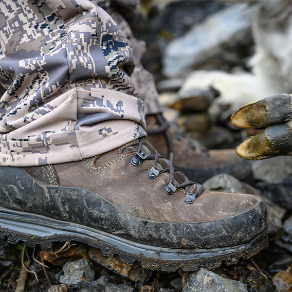Meindl Vakuum Hunter – Weathered Brown Leather Gore-Tex Hunting Boot Worn in Camouflage Gear While Crossing Rocky Terrain